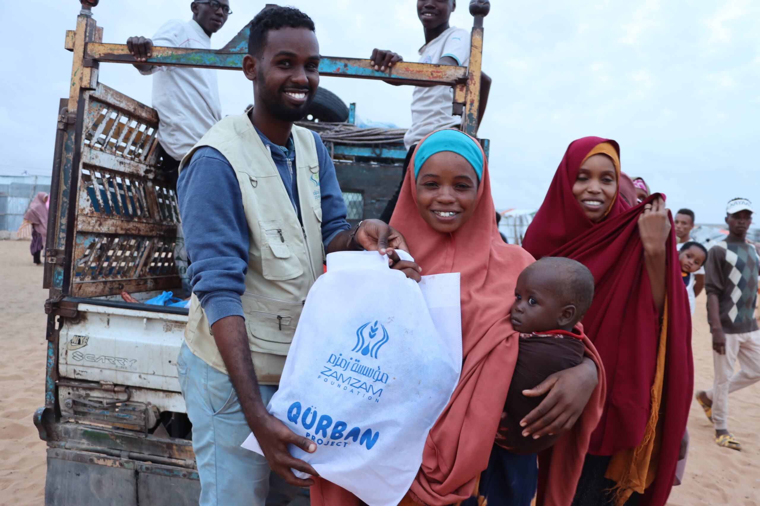 Qurbani 25 mum and child receiving from smiling staff member